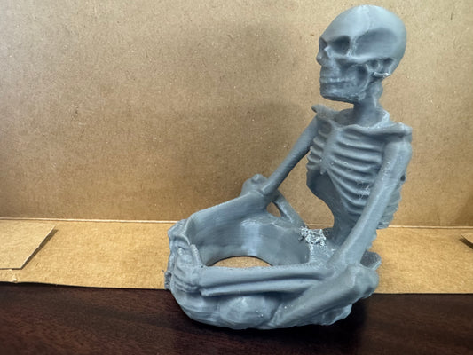 Sitting skeleton candle holder