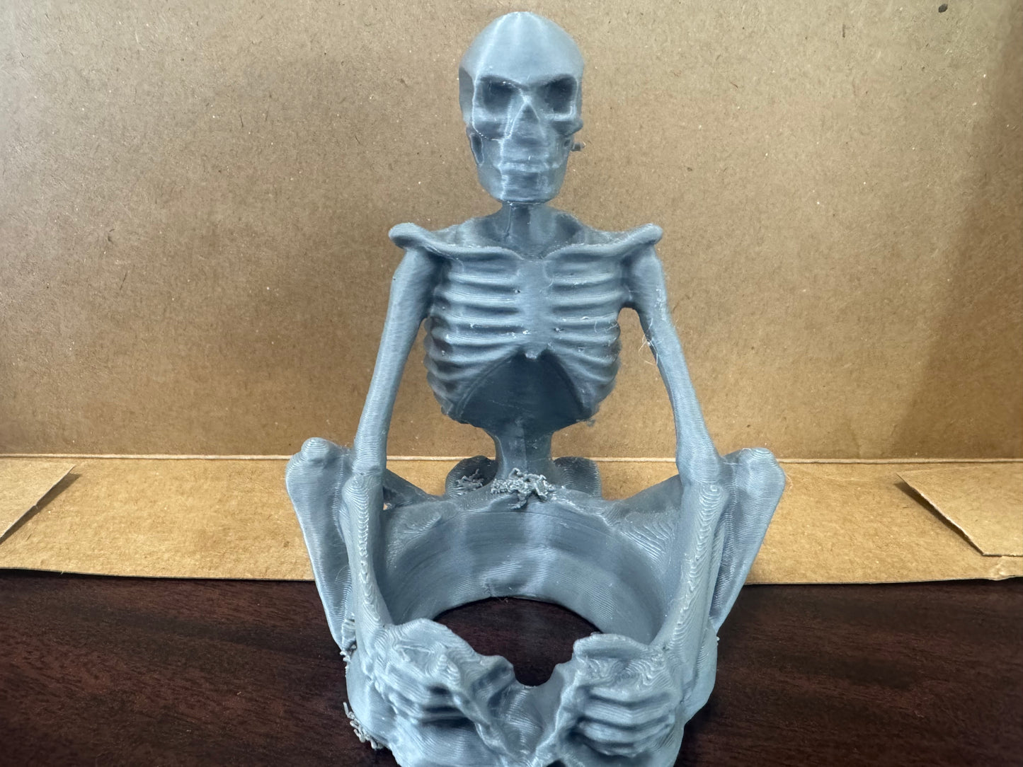 Sitting skeleton candle holder